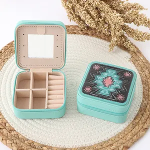 Detail view of mint green jewelry box with ethnic pattern top and interior mirror
