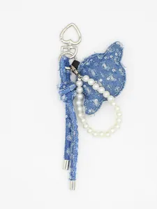 Dettaglio del ciondolo per borsa a forma di stella in denim blu fatto a mano con perle