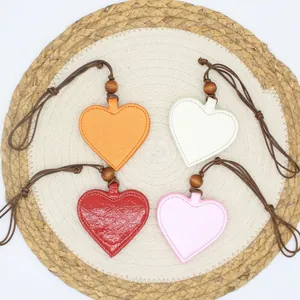 Heart-shaped PU leather magnetic eyeglass clips in four colors on woven mat detail