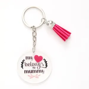 Close-up of acrylic keychain with pink tassel and 'my heart belongs to mummy' text