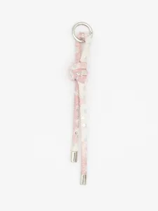 Dettaglio di ciondolo per borsa in denim rosa e bianco intrecciato con paillettes