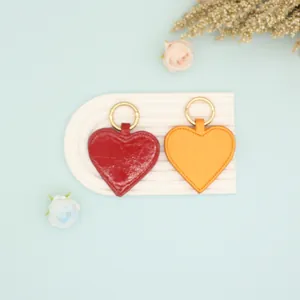 Detail view of heart-shaped PU leather magnetic hat clips in red and orange colors