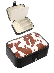 Detail view of a cow print western style jewelry box showing open and closed compartments