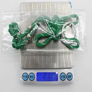Dettaglio del portachiavi a nodo cinese intrecciato verde che pesa 21,15 g sulla bilancia.