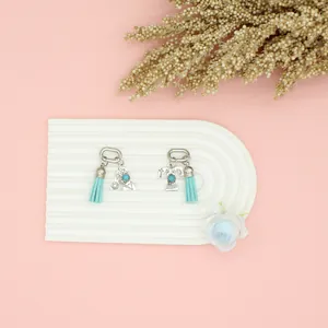 Detailed close-up of ethnic turquoise alphabet A & T charms with light blue tassels.