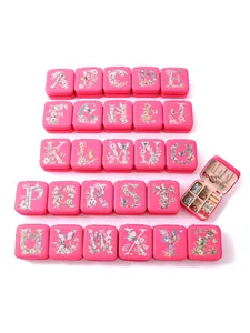 Detail view of 26 pink jewelry boxes with floral alphabet letters and open interior view