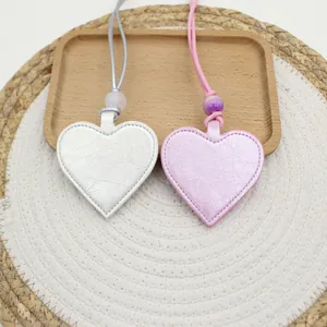 Close-up of silver and pink heart-shaped magnetic PU leather glasses clip pendants