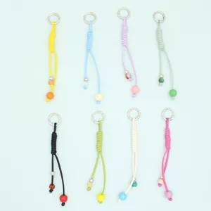 Detail of colorful handmade braided PU rope keychains with decorative beads.