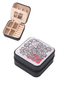 Detail view of portable jewelry box featuring floral lid with letter M and mirror