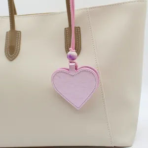 Detail view of a pink heart-shaped PU leather magnetic glasses holder on a tote bag