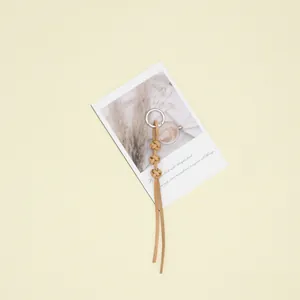 Close-up detail of handmade cowhide leather rope keychain with silver ring on prop card