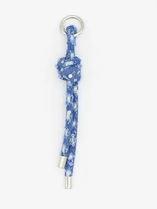 Primo piano dettagliato di un ciondolo per borsa in denim blu intrecciato con tocchi argento