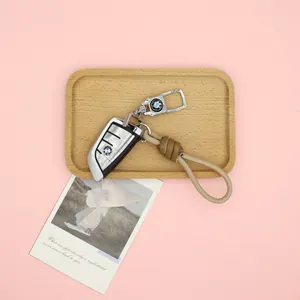 Detail view of a premium PU leather woven keychain strap on a wooden tray