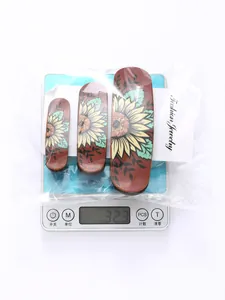 Set of 3 vintage sunflower hair clips shown on a scale measuring 32.3g total weight