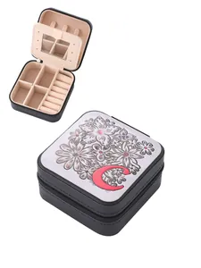 Detail view of portable jewelry box featuring floral embossing and red letter C