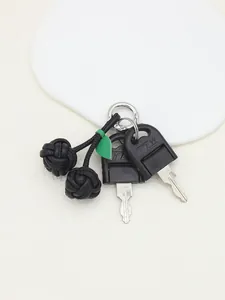 Detailed close-up of a handcrafted black PU leather cherry keychain charm.