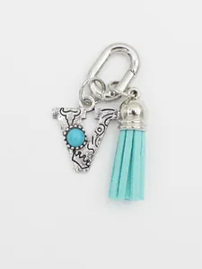Detailed view of silver ethnic initial V bag charm with turquoise and blue tassel