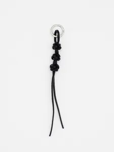 Detailed view of handwoven black leather keychain with knotted design and silver ring