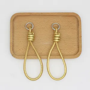 Close-up view of elegant gold woven PU leather loop charms with silver metal rings