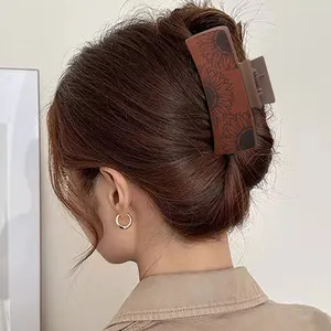 Detail of a Western retro sunflower hair claw clip in PU leather worn on hair.