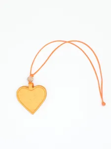 Detail view of a heart-shaped yellow PU leather magnetic glasses holder with strap.