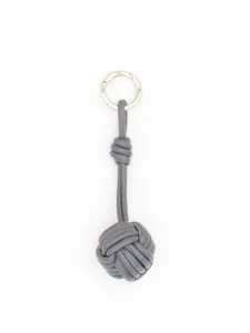 Detail view of a handmade grey PU leather knotted ball keychain with silver ring