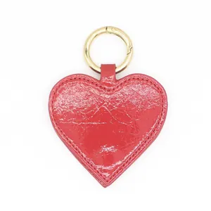 Glossy red heart-shaped PU leather magnetic hat clip with elegant gold spring ring fastener.
