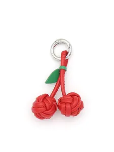 Detail of hand-braided red PU leather cherry keychain charm with silver ring
