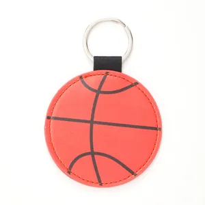 Detail view of a basketball style leather keychain with metal ring on white background