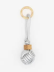 Macro view of hand-woven silver PU leather ball charm featuring a natural wooden bead