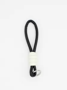 Detail view of a minimalist black and white PU leather braided wrist strap keychain