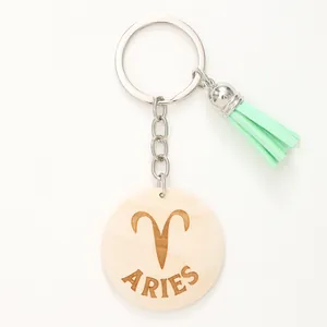 Dettaglio del portachiavi Ariete in legno con nappina verde menta e simbolo inciso