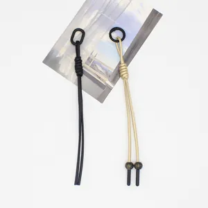 Detail view of handmade braided PU rope charms in black and gold with decorative beads
