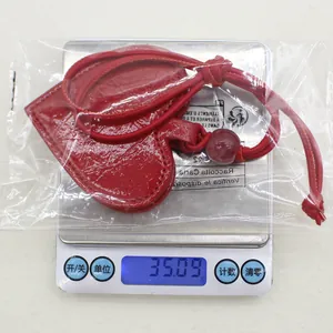 Detailed macro shot of red heart PU leather glasses clip pendant weighing 35.09 grams