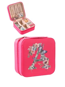 Detail view of pink portable jewelry box with floral letter A and storage compartments