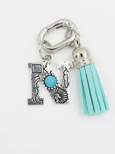 Detailed view of an ethnic style alphabet N charm featuring turquoise and a blue tassel