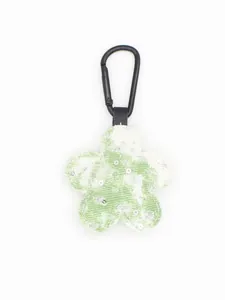Detalle de un llavero de flor de tela a cuadros verde con lentejuelas y clip metálico