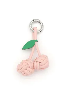 Detailed view of a handmade pink woven PU leather cherry charm with silver metal ring.