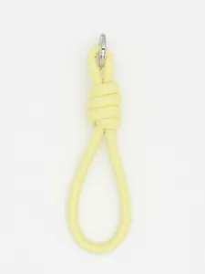 Close-up of minimalist pale yellow PU leather knotted wrist strap with silver clasp