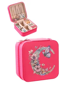 Portable magenta jewelry box featuring floral letter C design and organized interior storage