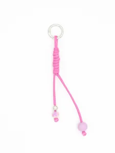 Detailed macro view of a handmade woven pink PU leather keychain with purple beads.