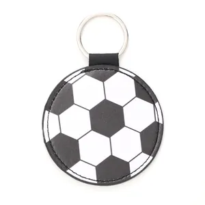 Detailed view of a round soccer pattern leather keychain with a metal ring on white background