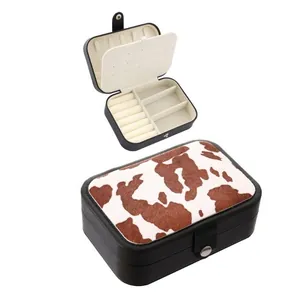 Cow print jewelry box with faux leather exterior and multiple compartments