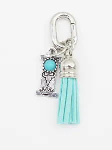 Close-up of ethnic style silver alphabet I charm with turquoise and blue tassel