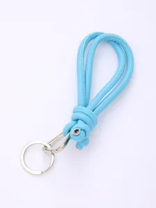 Detailed view of handmade light blue PU leather knotted strap with silver keychain