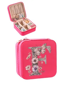 Detail view of portable pink jewelry box featuring an alphabet F and floral art