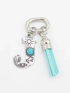 Detailed view of ethnic turquoise letter J charm with light blue suede tassel accessory