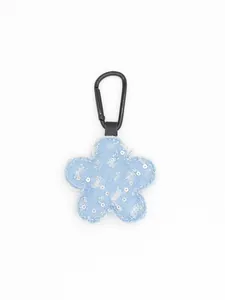 Detalle de un llavero de flor de mezclilla azul con lentejuelas y clip