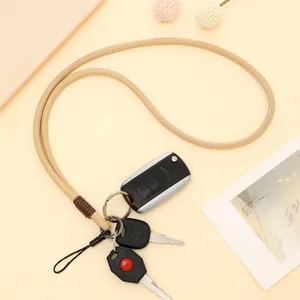 Μπεζ πλεκτό δερμάτινο λουράκι λαιμού με κλειδιά αυτοκινήτου σε μπεζ μίνιμαλ φόντο