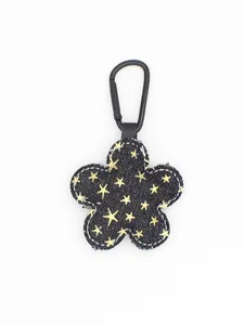 Detalle de llavero de flor de mezclilla con estrellas y mosquetón negro